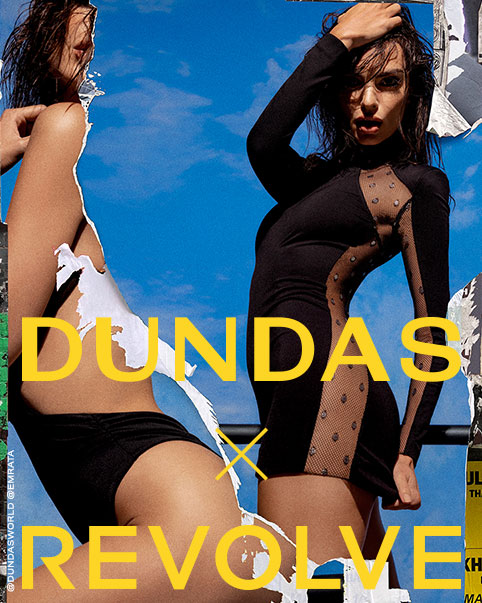 Emily Ratajkowski wearing a black long sleeve mini dress with sheer mesh trim. DUNDAS x REVOLVE. Shop the Collection.