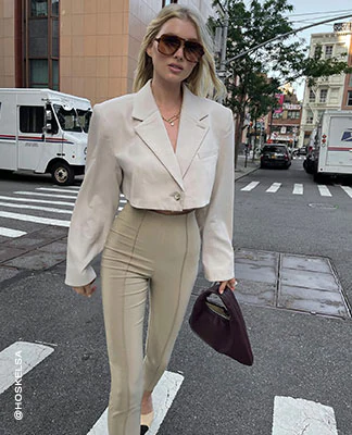 Elsa Hosk wearing sunglasses, a cream cropped blazer and tan pants. All the Fall Feels. Shop the Edit.