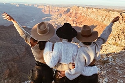 Three friends looking over The Grand Canyon